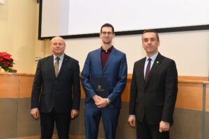 Trzech mężczyzn pozuje do zdjęcia.