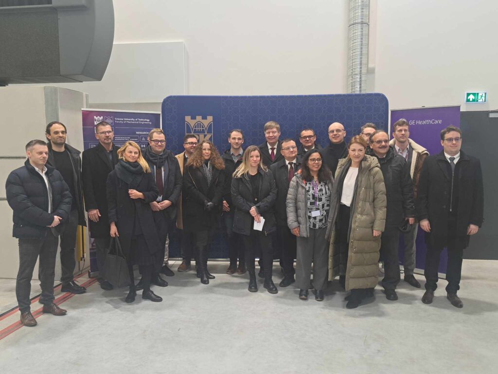 grupa osób pozuje do zdjęcia na tle kolorowych ścianek z logo PK